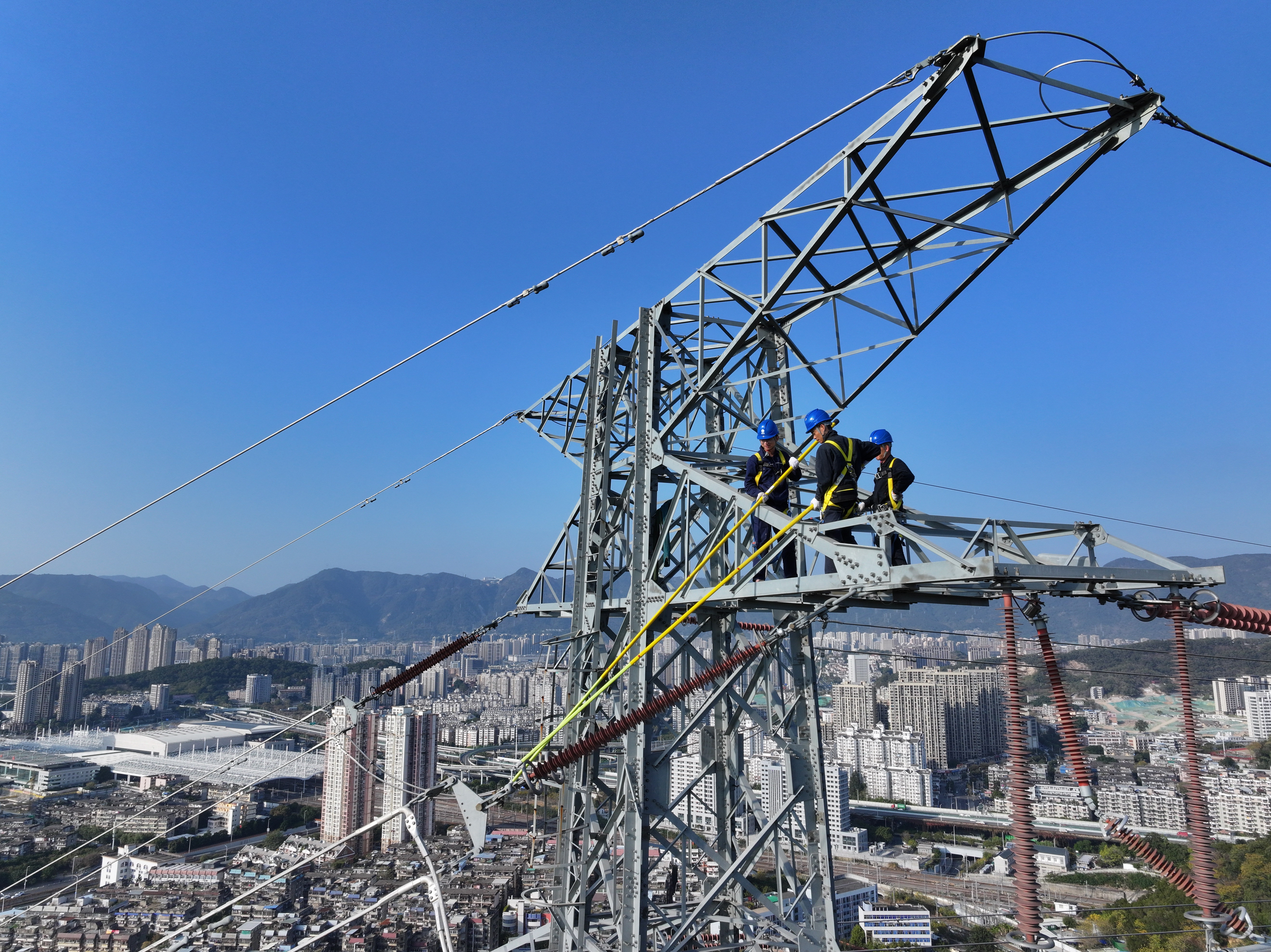 1月16日福建福州供电公司员工吴能锦、廖肇葵和陈端枢在福建省福州市晋安区金鸡山220千伏榕公线37号塔对金具、绝缘子串等设备进行检查维护。（陈德钧）1.jpg