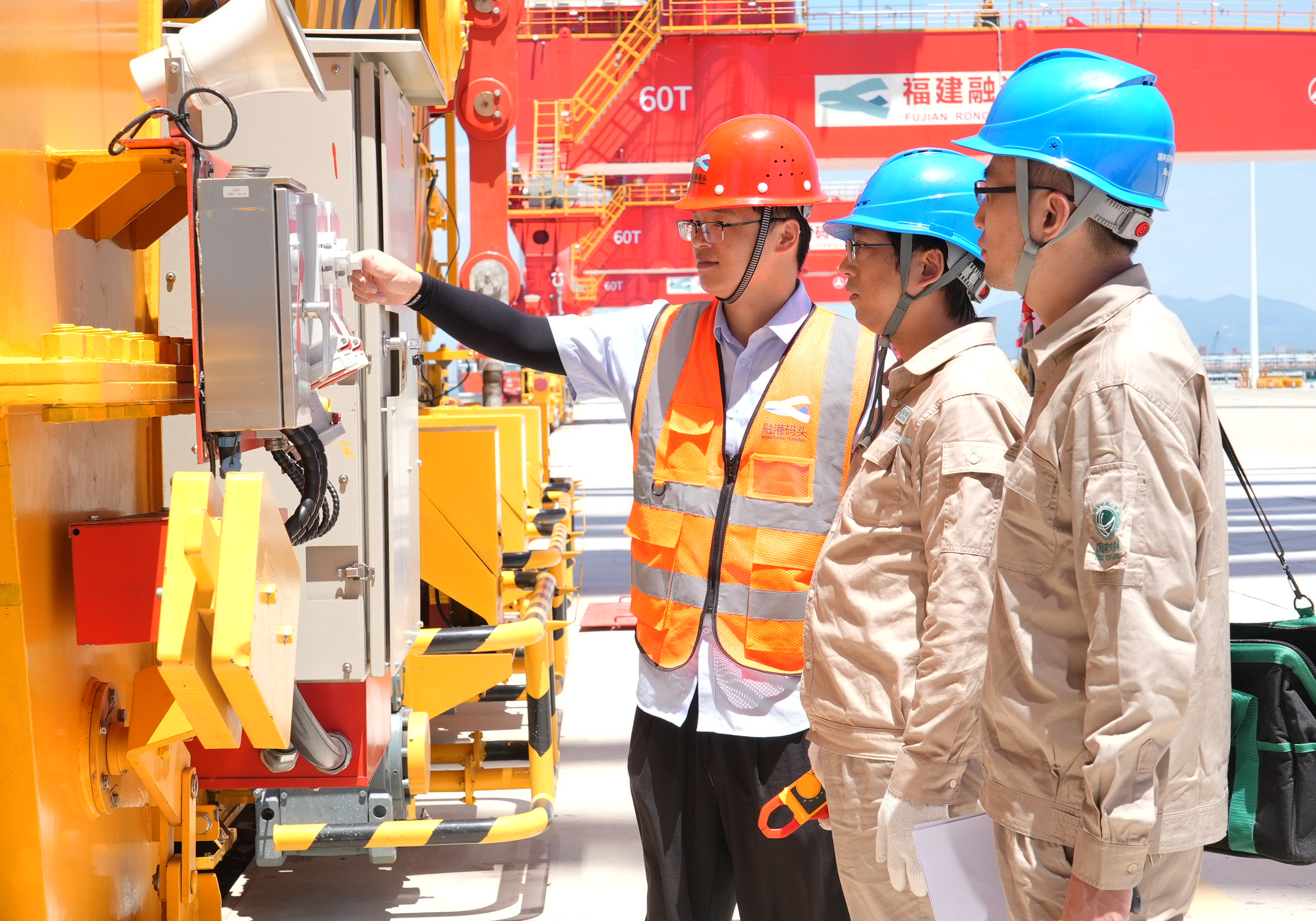 7月3日福建福州供电公司员工林森和钱骅冒着40℃的高温对福建省东北地区首个零排放全电动码头——融港码头的电动龙门吊的供电线路进行巡检（陈德钧）.jpg