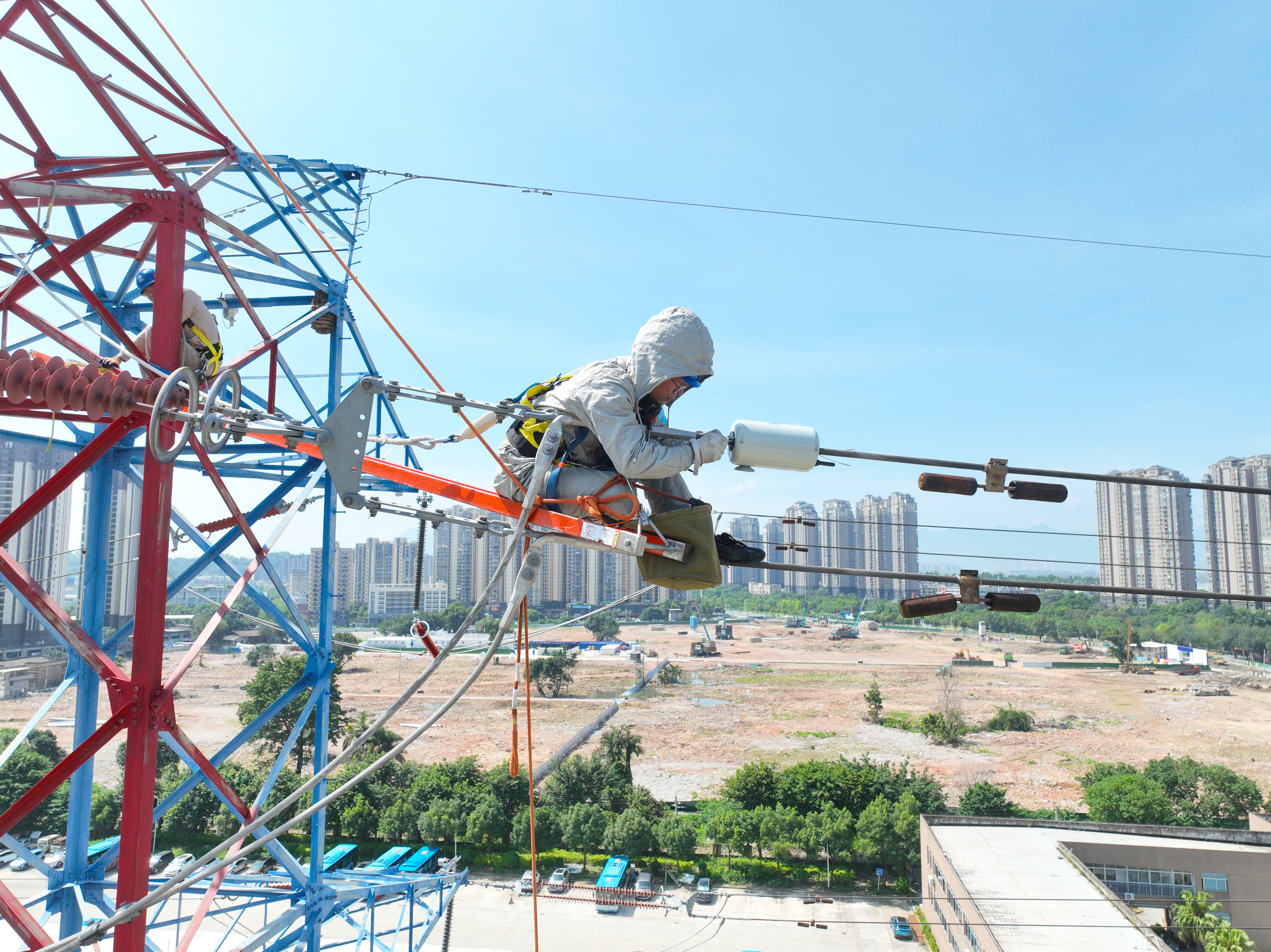 6月23日福建福州供电公司员工林信恩、郑孝干和卓晗等冒着高温在福建省福州市浦上大道220千伏建高线4号塔上为线路带电安装负荷监测装置。（陈德钧）.jpg